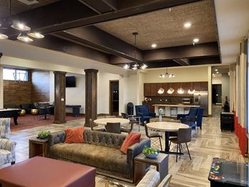 A large room with a couch, chairs, and a dining table